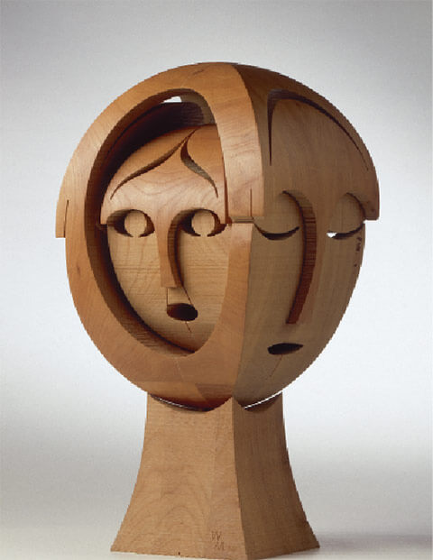 Elliptischer Kopf mit 4 Gesichtern, 1992, Kirschbaumholz, 55 x 26 x 26 cm.  Foto Walter Grunder. Elliptische Umrisse ergeben den in sich ruhenden Kopf