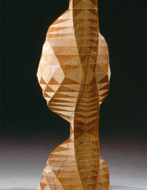 Polyederische Büste, 1994, Nussbaumholz, 60 x 24 x 18 cm, Foto: Walter Grunder.  Die vertikalen Flächen sind Sägeschnitt, die schrägen sind lackierter Feinschliff
